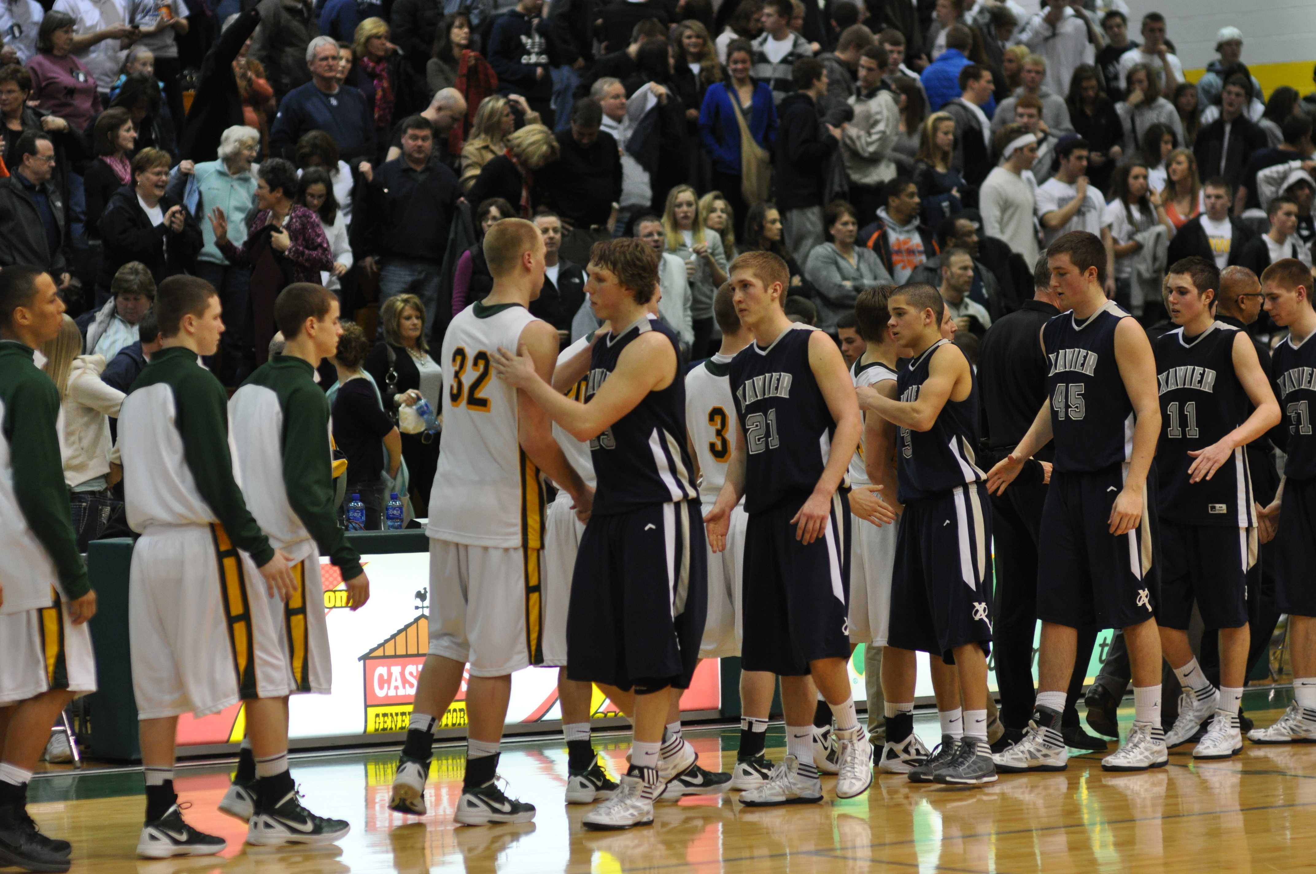 Kennedy and Xavier players tell each other good game after the Cougars defeated the Saints 59 to 45.