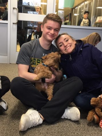 Jackson Middlekauff (left), sr., and Jazmine Loomis, sr., play with one of the 8-week old puppies.