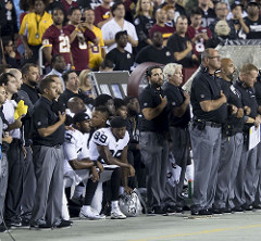 Oakland Raiders teammates kneel during the national anthem before a game against the Washington Redskins at FedExField on September 24, 2017 in Landover, Maryland. 