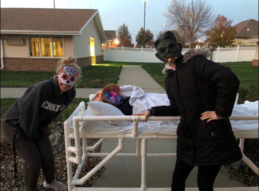 Hailey Dolphin, sr., and Olivia Haefner, jr., pose next to Gwyn Smith, jr., as she waits to put on a scare.