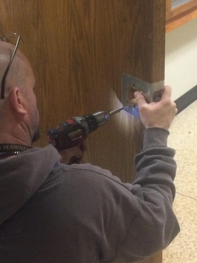 District facility technician changing the door knobs.