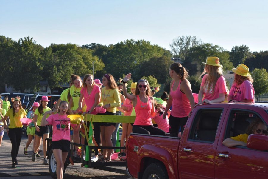 Girls swimming parading in neon outfits.