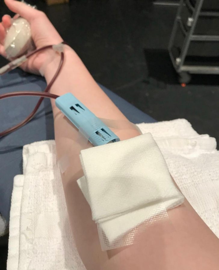A student donates blood in the Kennedy Black Box.