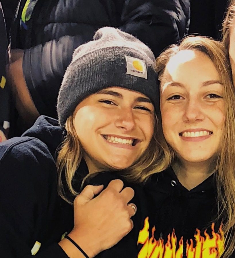 Seniors Riley Hull and Jennifer Schmidt wearing all black at a Kennedy football game at Kingston Stadium.