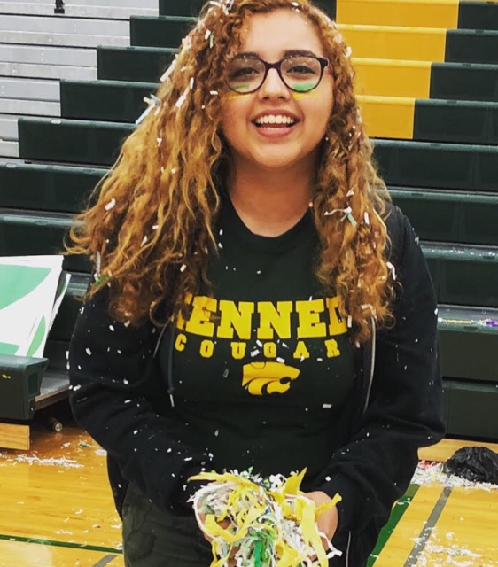 Jackie Garcia attending a pep assembly at Kennedy High School, posing with handfuls of confetti.