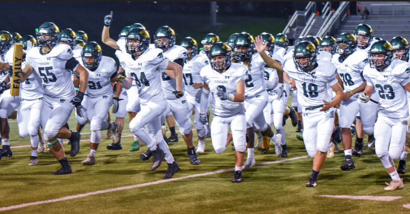 The Kennedy Varsity Football team running towards the student section after winning their latest game against the Linn Mar Lions.