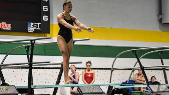 Kennedy swimmer preparing to dive into the pool at their meet.