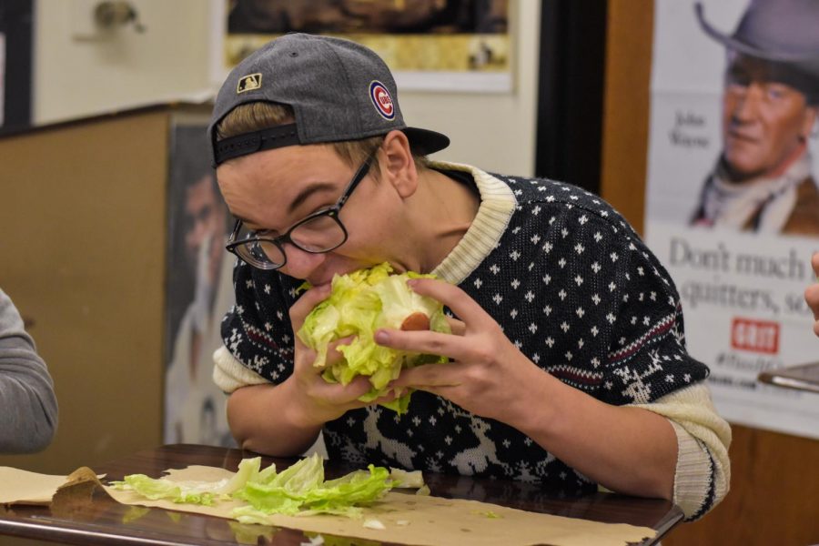 A Lettuce Club participant takes a big bite of lettuce. 