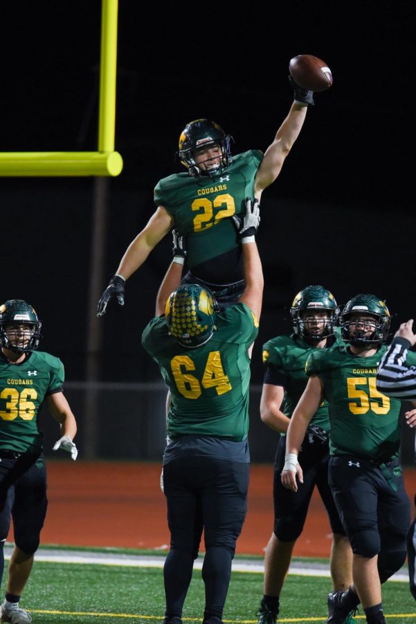 #22 Alex Koch is lifted by #64 Ethan Mills in celebration of his touchdown.