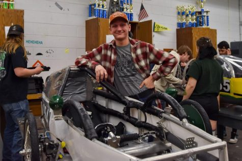 Brian Stubblefield shows off one of the hand-made electric cars in Barry Wilson’s classroom.