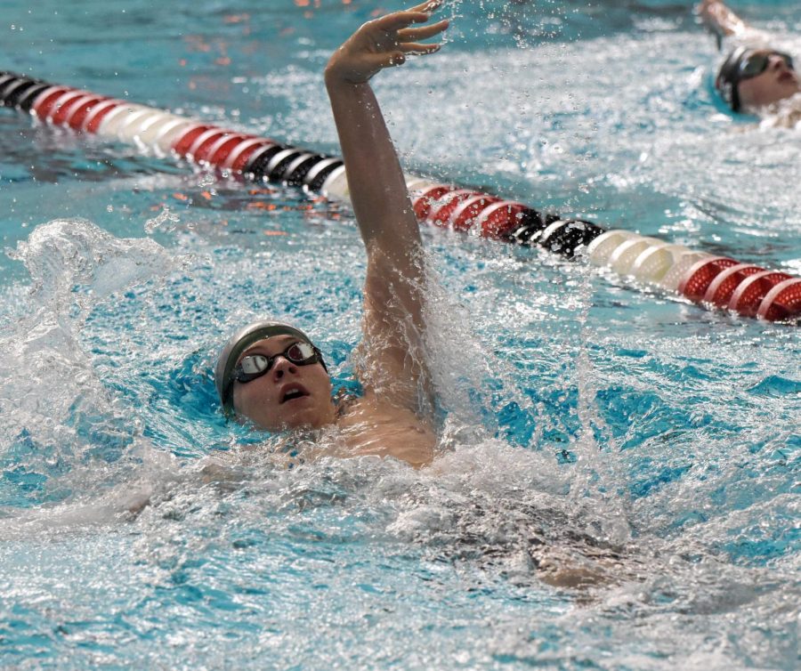 100 Yard Backstroke is sawm Tyler Brekke, picking up the pace as he approaches the end.
