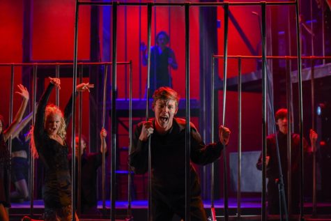 Sophomore Jordan Harvey sings through jail bars.