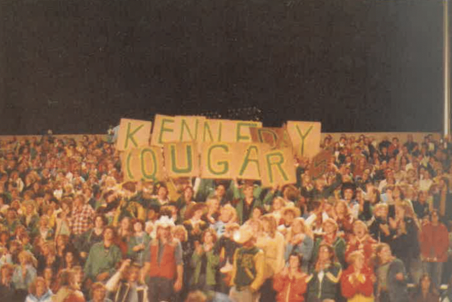 Cougars raise a sign during an outdoor pep assembly.
