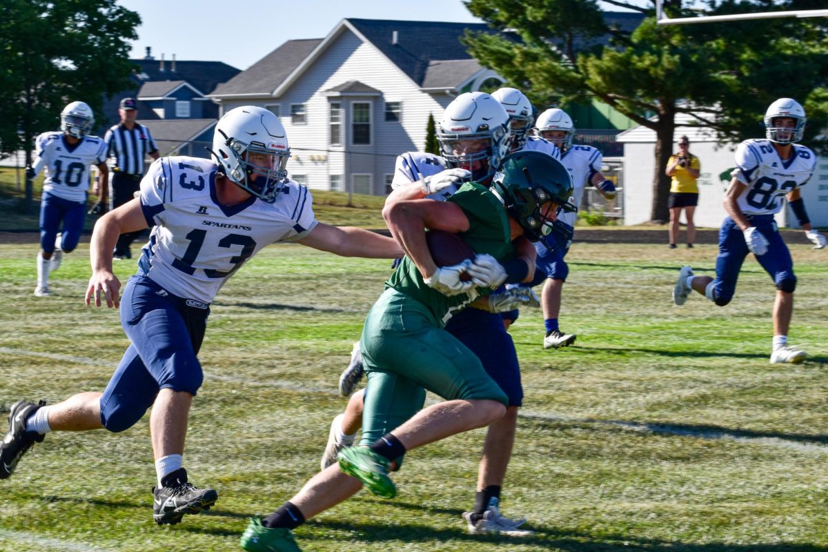 27 football player, #7 Atley Gloede, pushes through defense to get a touchdown. 