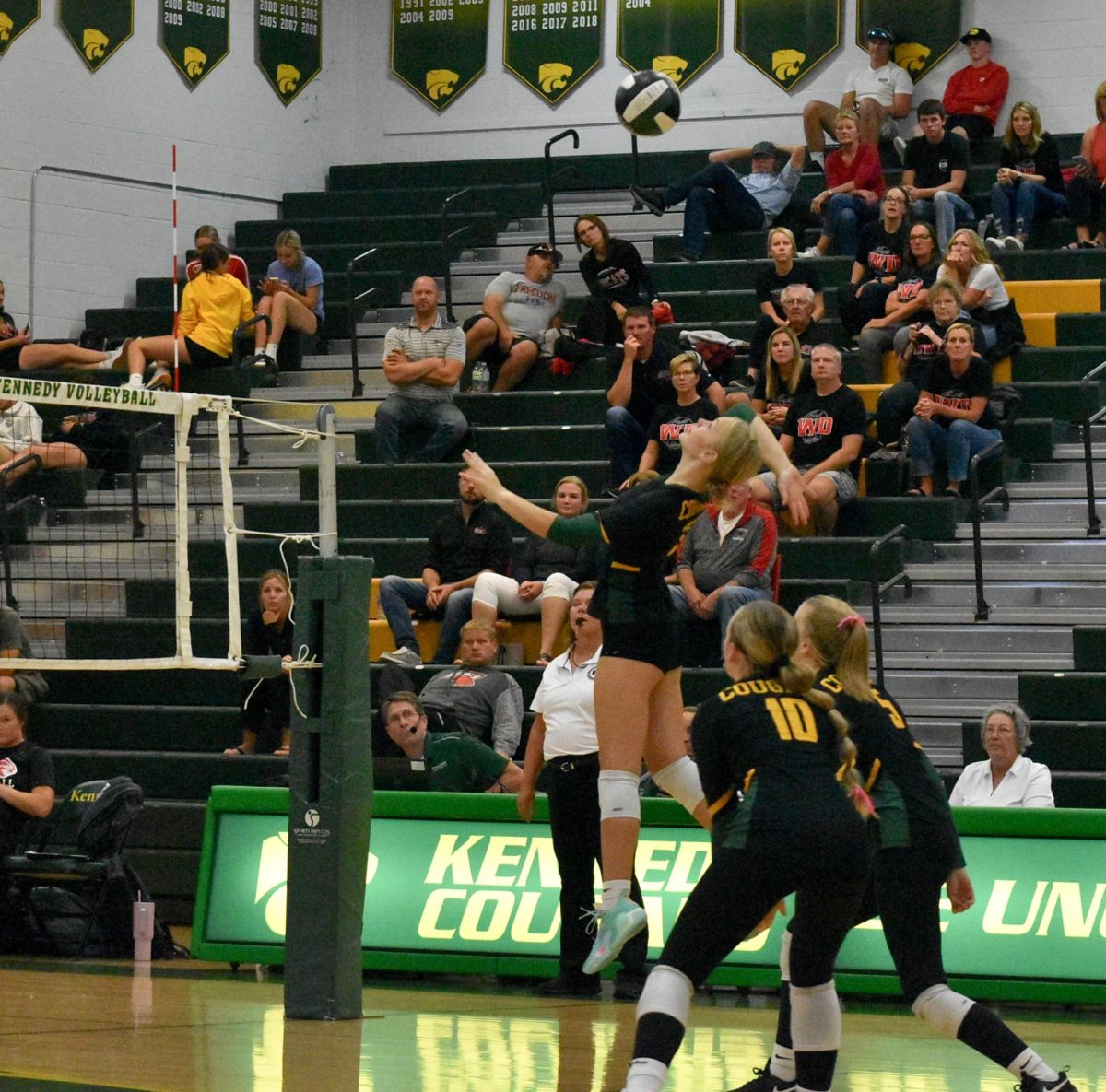 Ousley hits the ball while Aliya Ballard and Maren Diederich cover her.