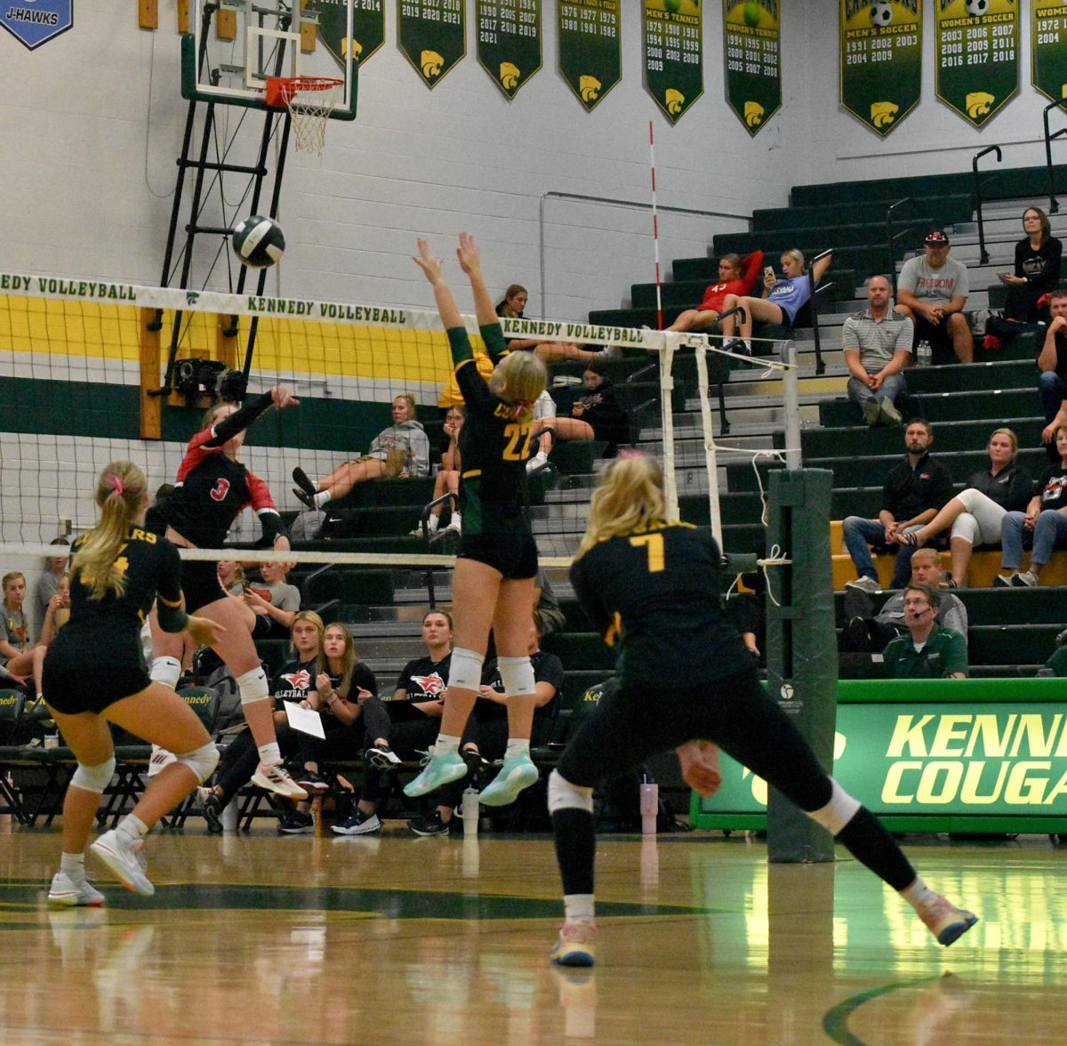Varsity freshman Skyylan Ousley goes up for a block against Western Dubuque hitter.
