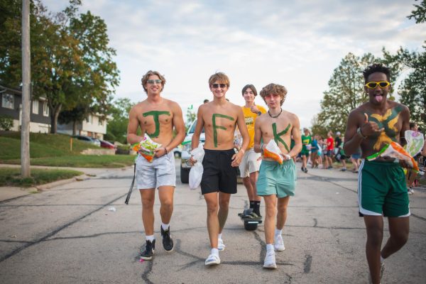 Senior cross country representatives Ben Knipfer, Alex Volden, and Kyler Zimmerman (left to right) walk the parade.