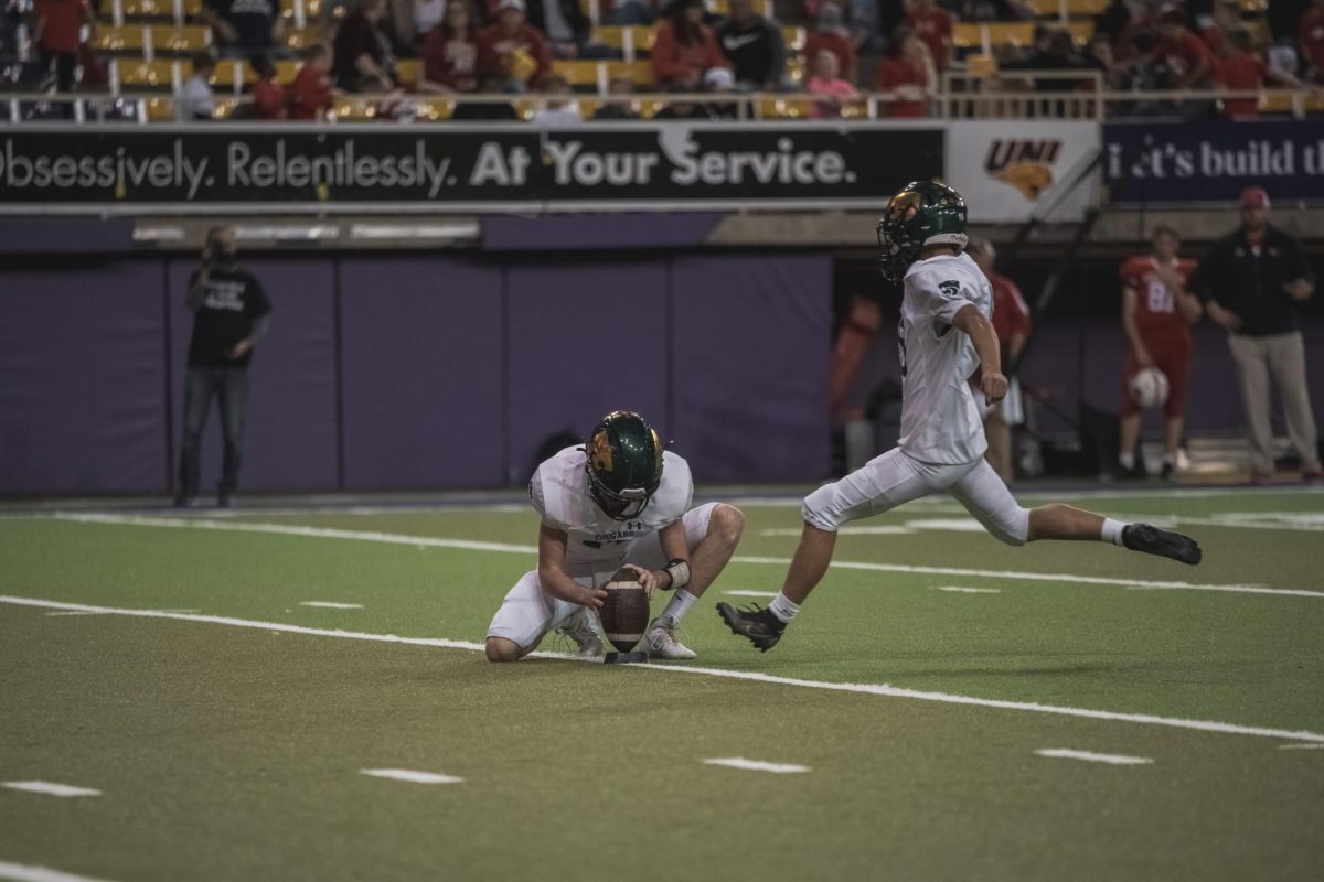 Winding up, senior kicker Dylan Augustine  attempts the extra point following a touchdown.