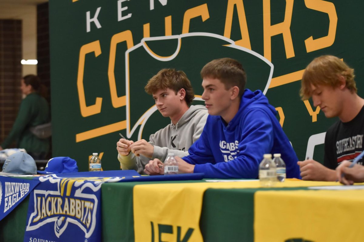 Matthew Stoltenburg and Nolan Grawe prepare to sign. 