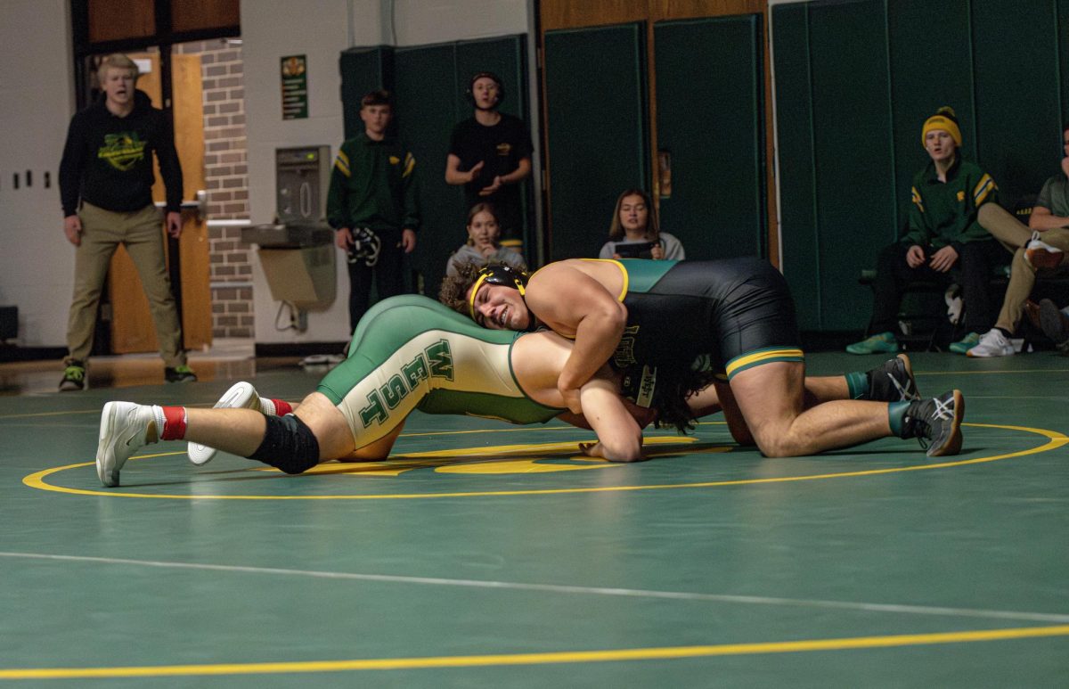 Trying to flip his opponent, senior Austin Raue pushes for a win.