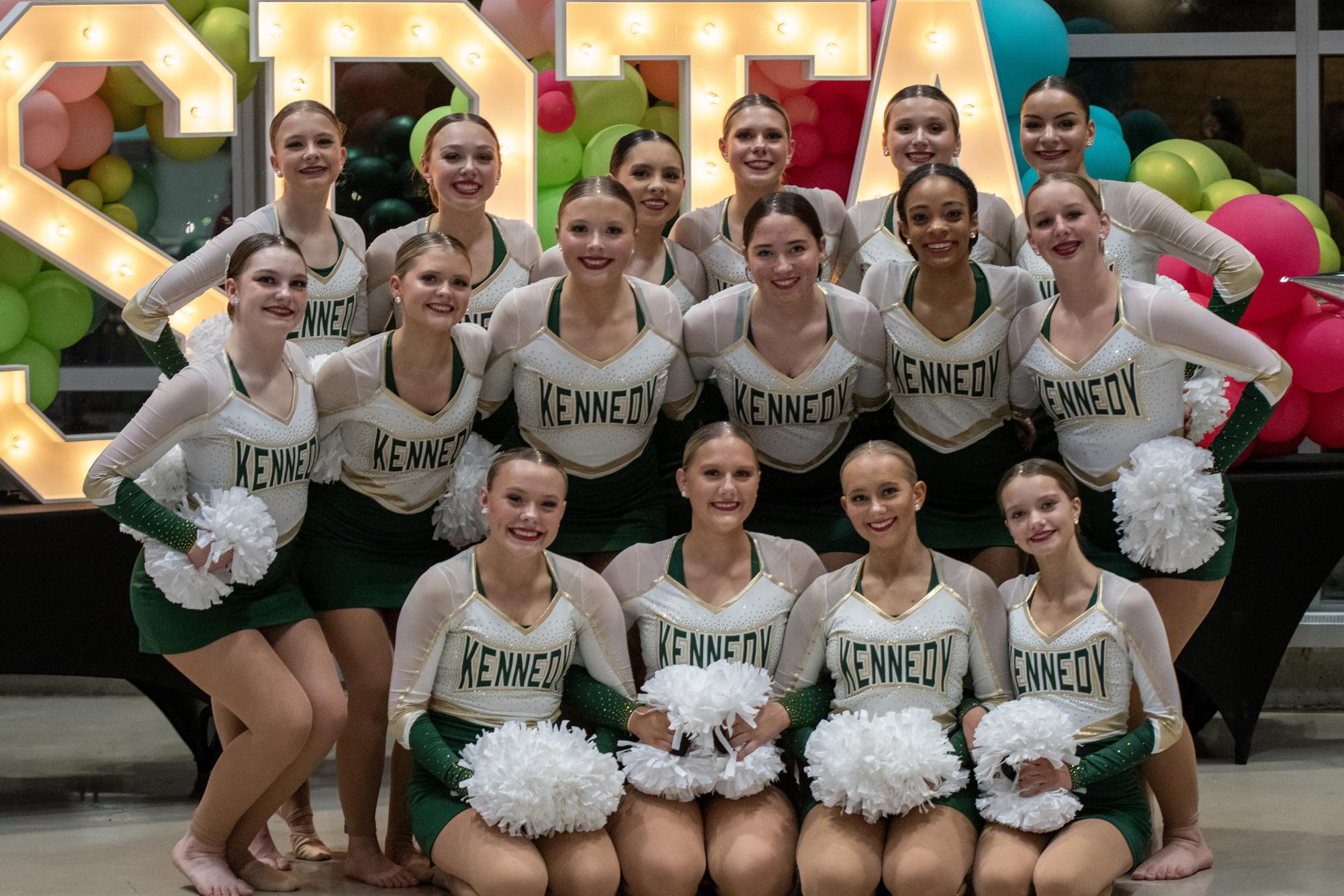 Kennedy Dance Team poses infront of the ISDTA sign.