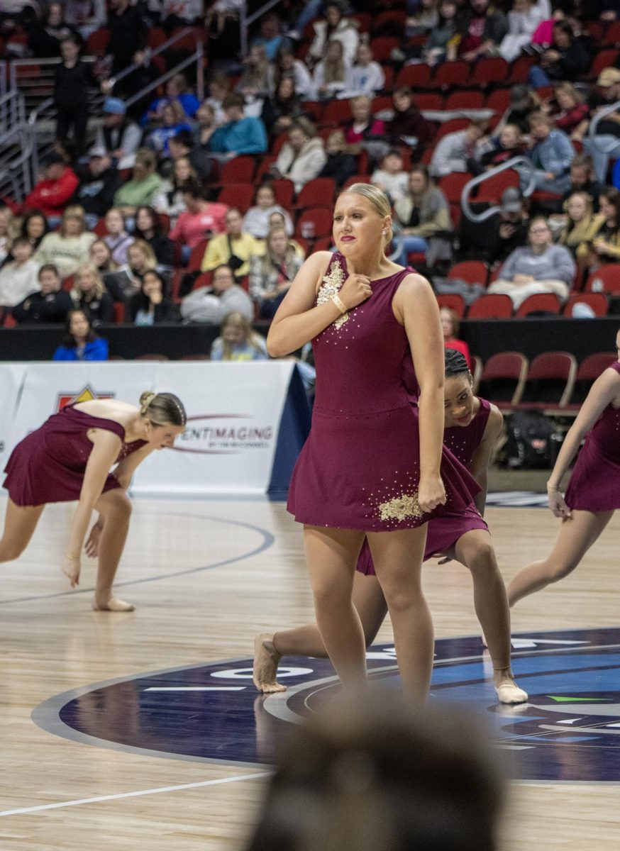 Expressing her emotions at her last state performance, senior Aubrey Wolf stands during the group dance.