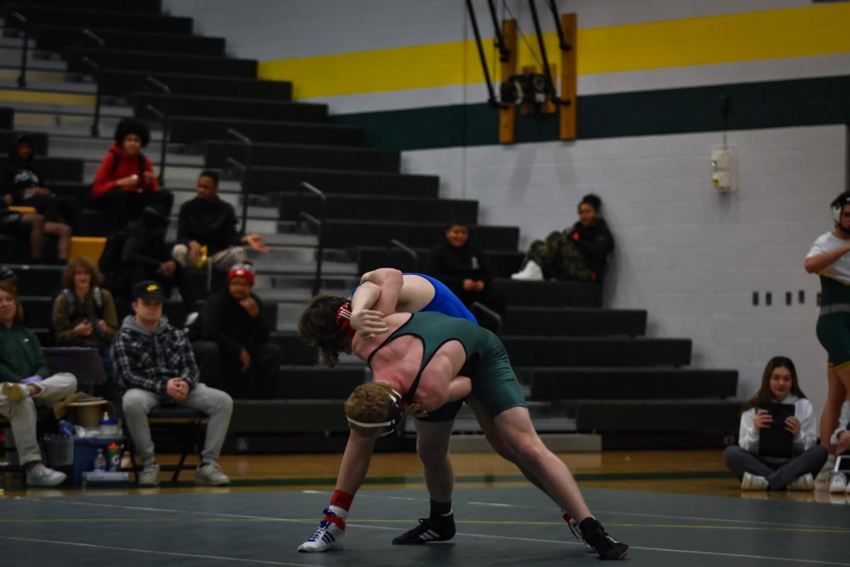 Fighting against a headlock, a Kennedy wrestler pushes against