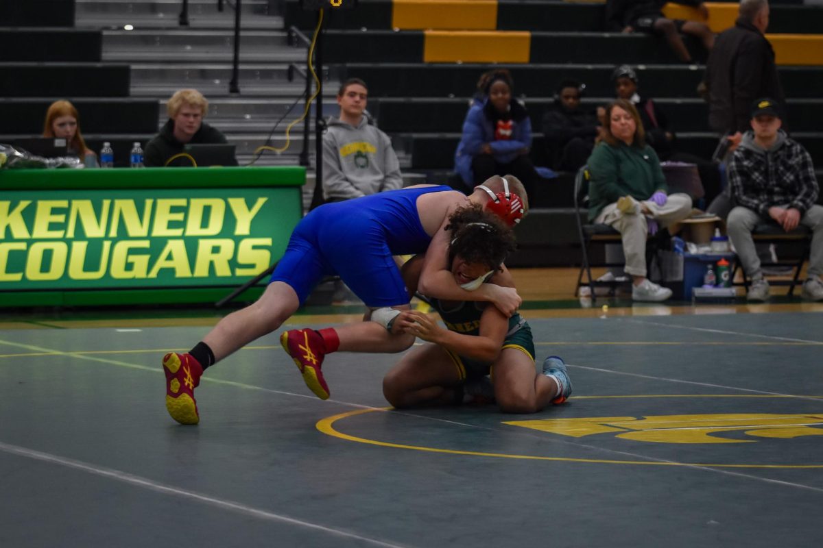 With the lower leverage, a Kennedy wrestler holds back a driving push from his opponent.