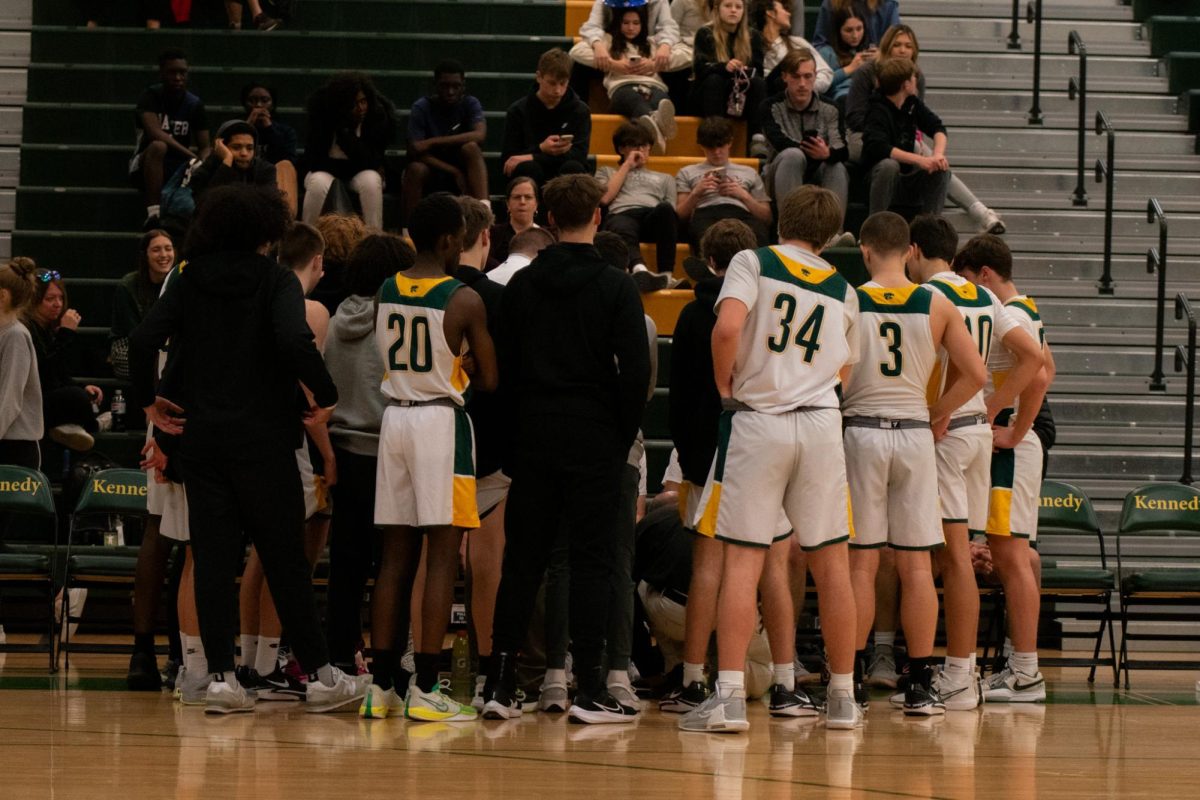 The sophomore Kennedy Boys Basketball Team huddles during a timeout to discuss their game plan.