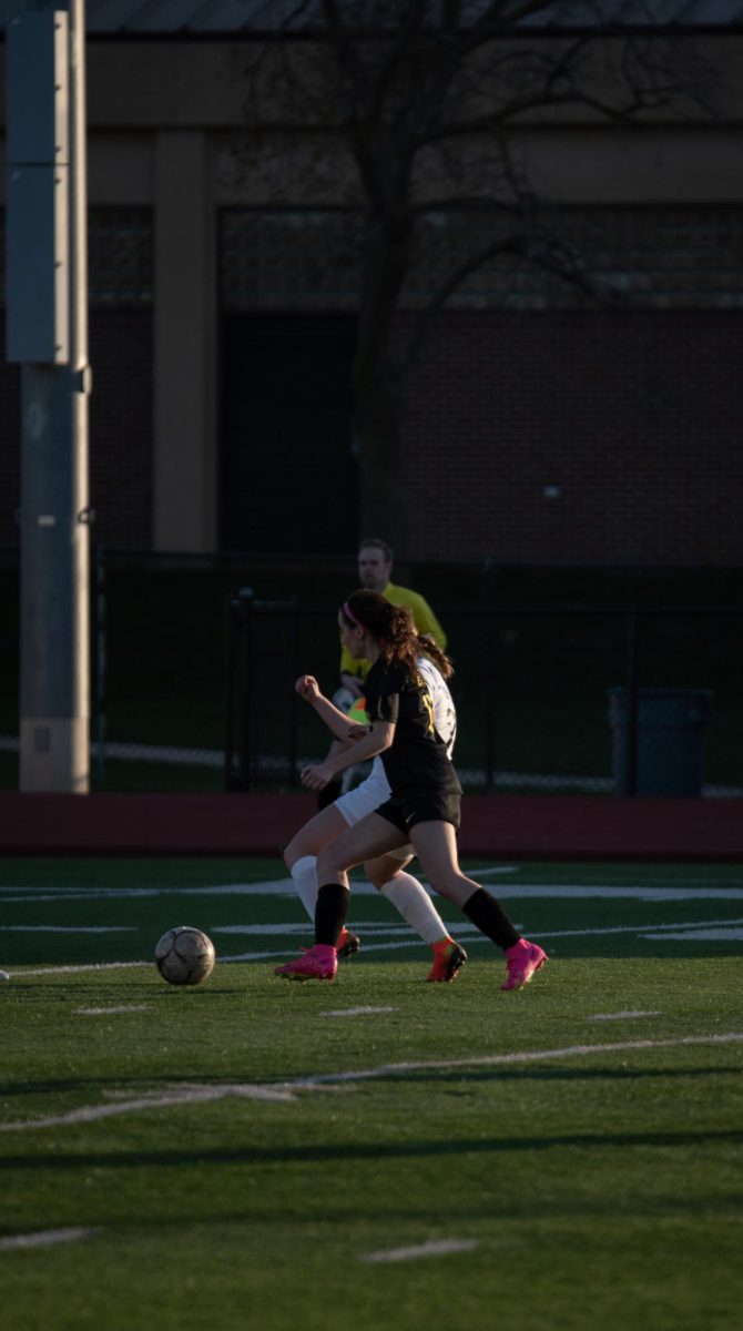 Down the field, senior Olivia Klein follows the ball.