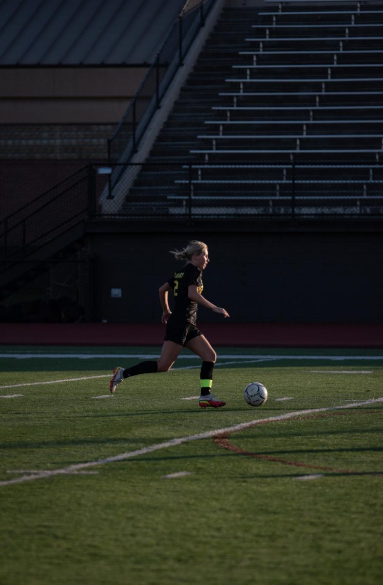 Running down the field, senior captain #12 Liza Scherbring goes for the goal.