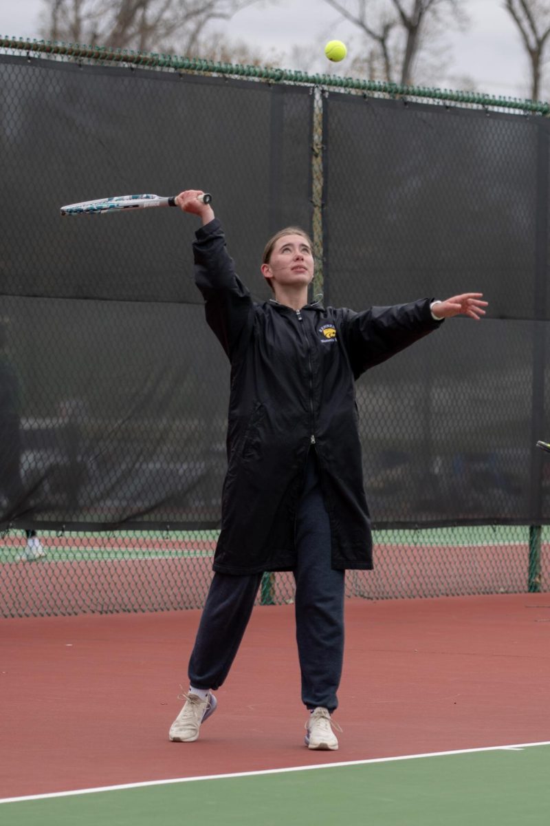 Freshman Eva Larsen watches her toss before she serves.