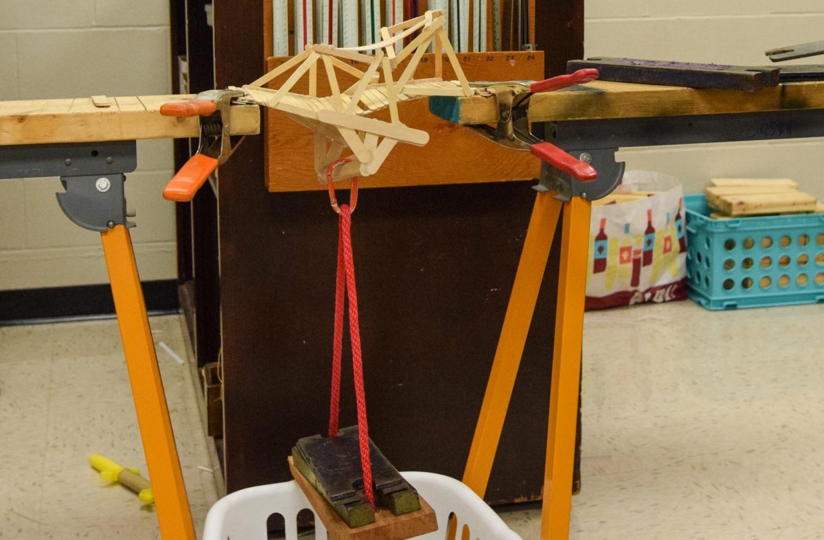 Students' bridge design falls apart during weight testing. 