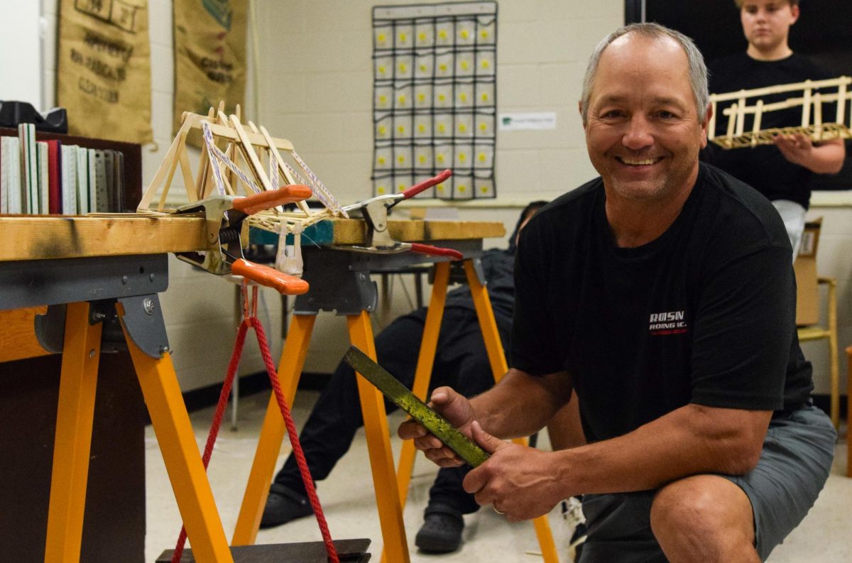 Instructor Brain Jeffords adds weight to a bridge. 