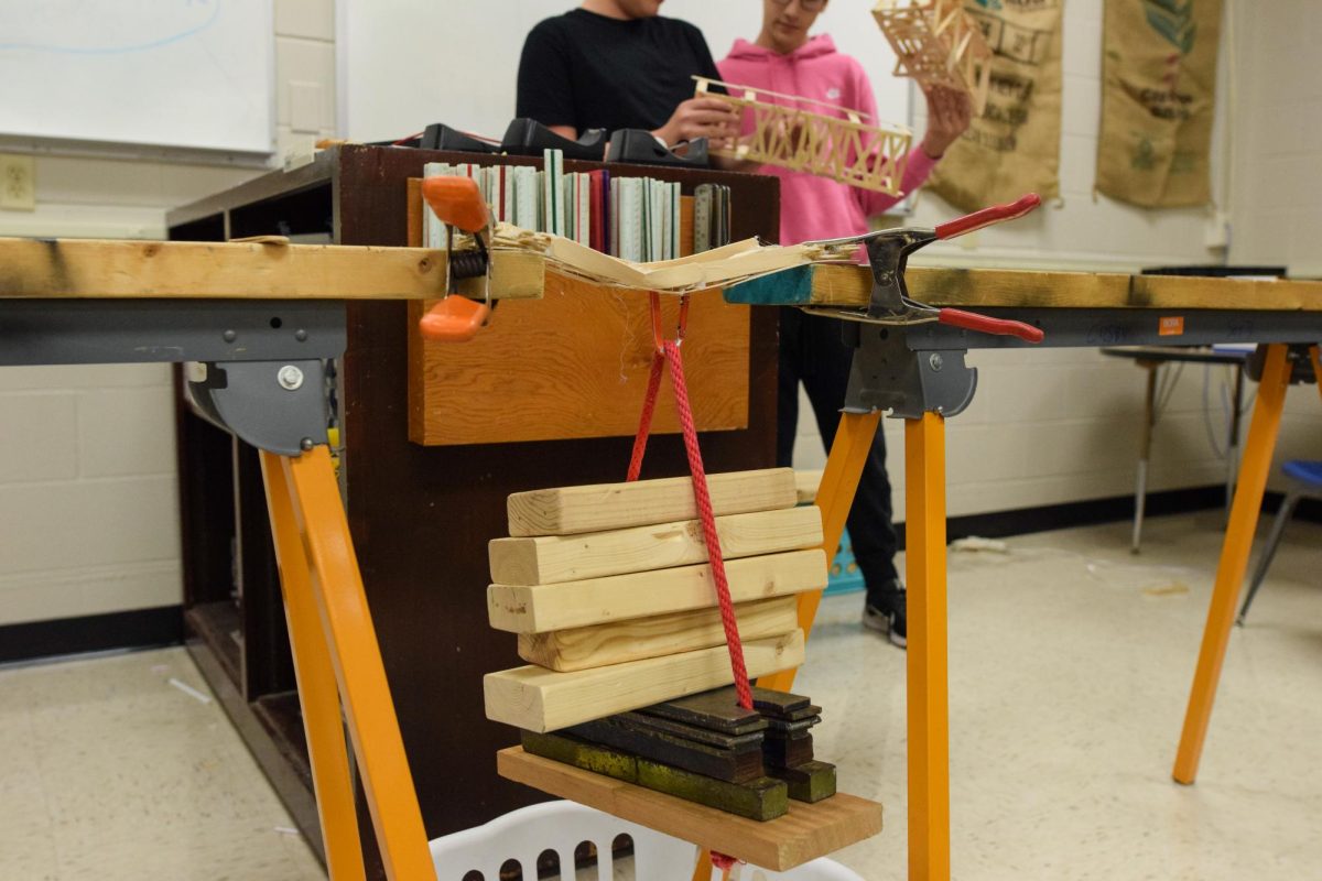 A bridge design by students is tested with weights. 