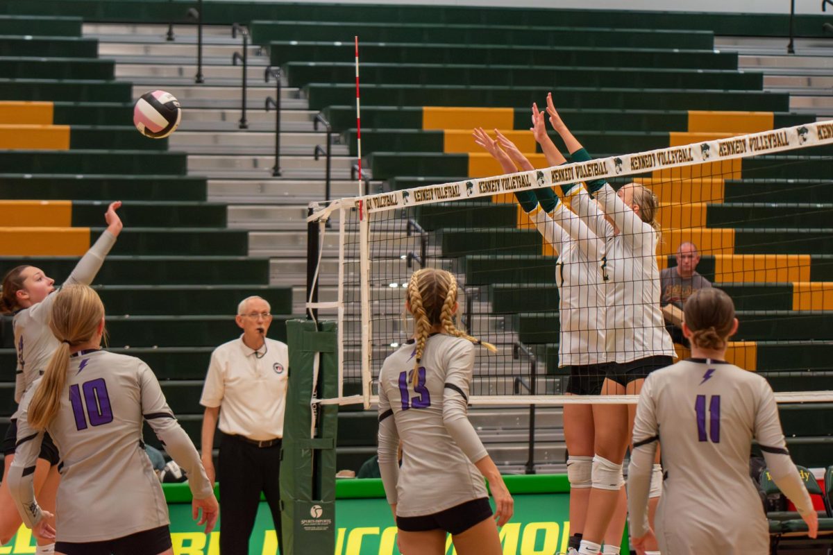 Freshman Keira Mueller and sophomore Peyton LeMieux block a Liberty player at the net. 