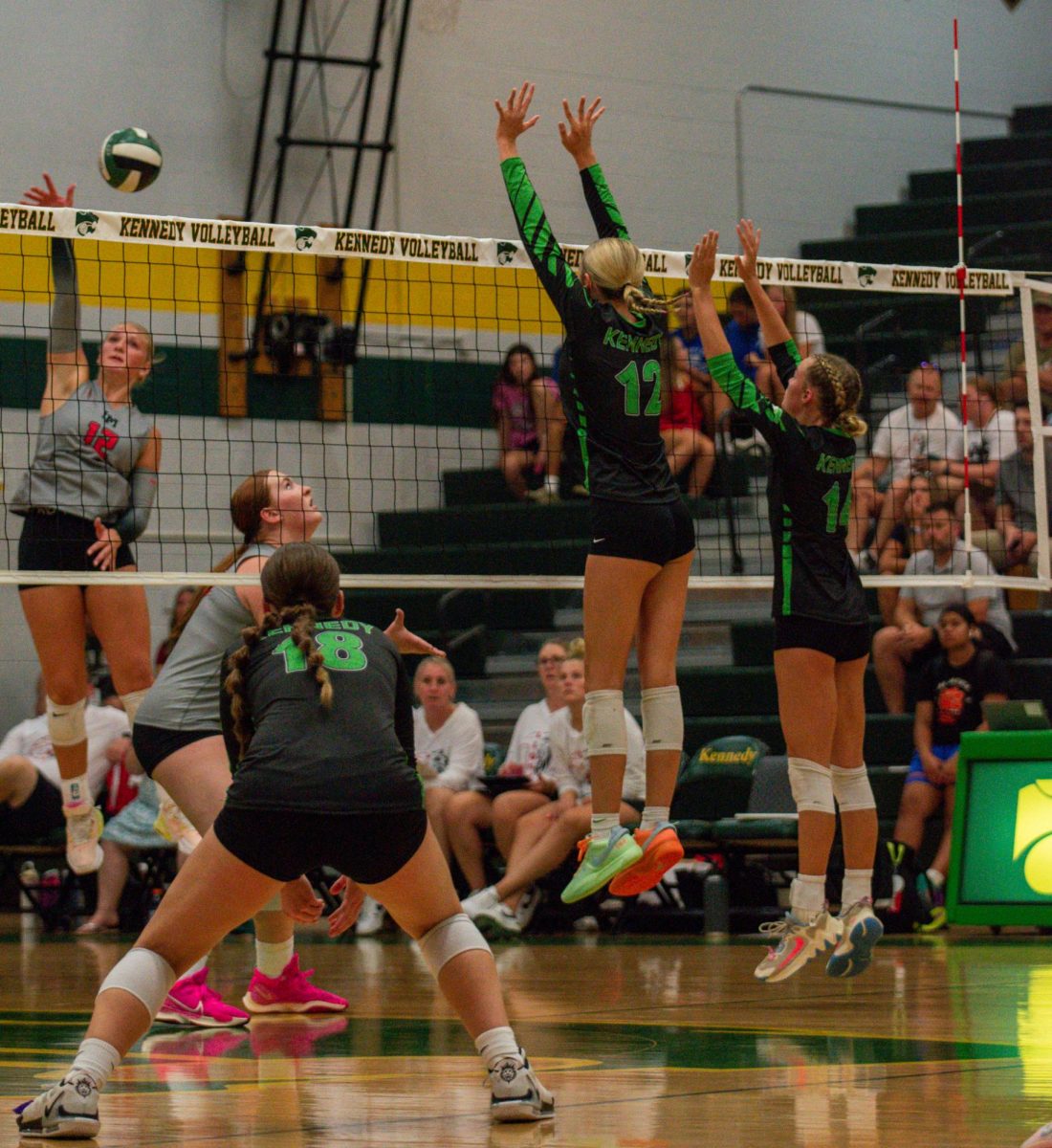 Sophomores Addy Phillips and Charley Lovell block the Linn-Mar hitter at the net while Amling covers the off-block.