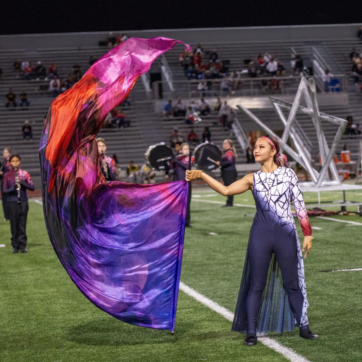 In unison with her teammates, sophomore May Turner spins her flag.