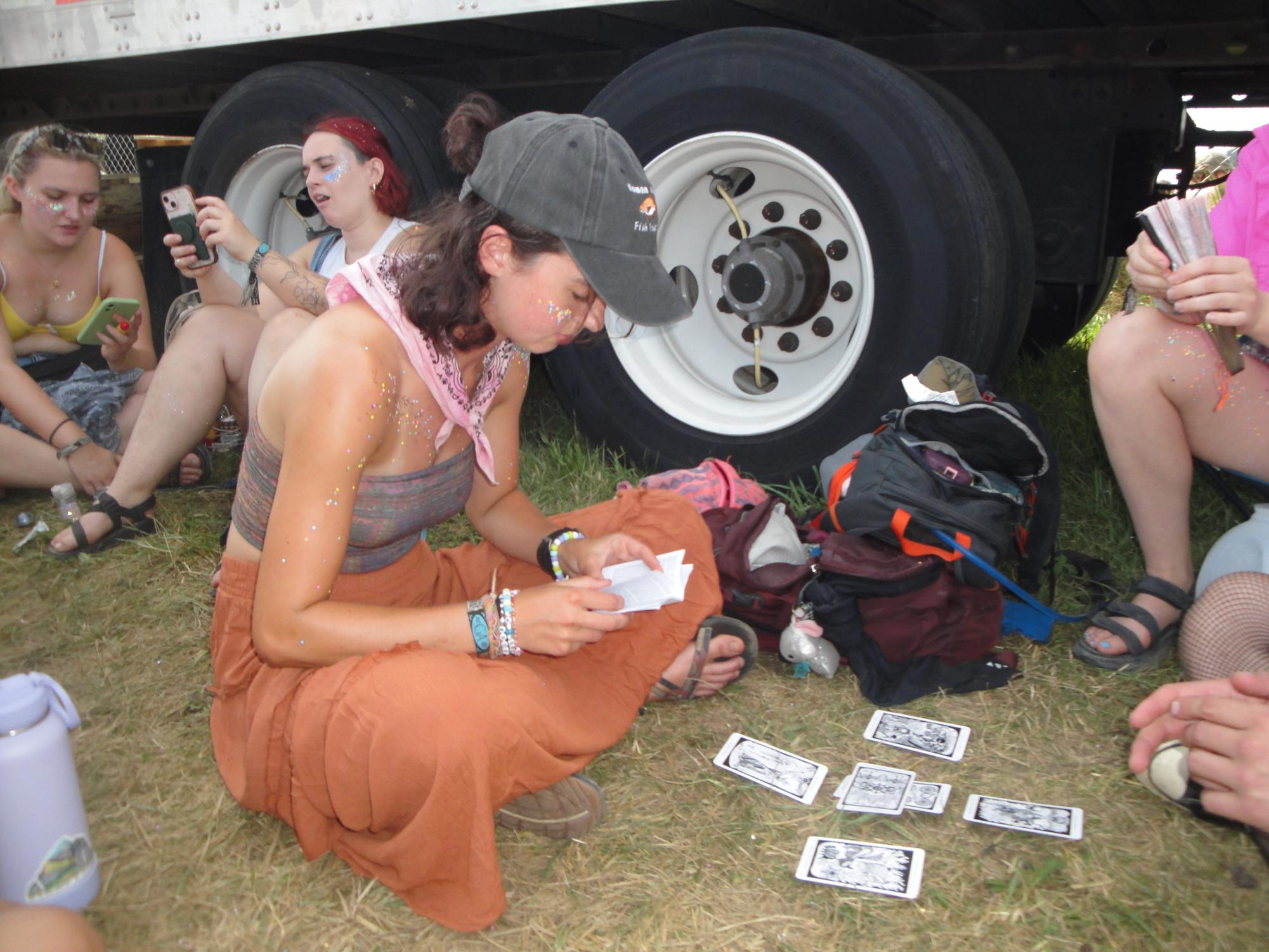 Hinterland patron Anabel Bradley reads tarot cards for another spectator as she waits in a several-mile-long line to enter the festival.