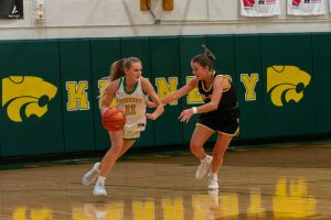 Freshman Bentley Dill runs down the court while protecting the ball.