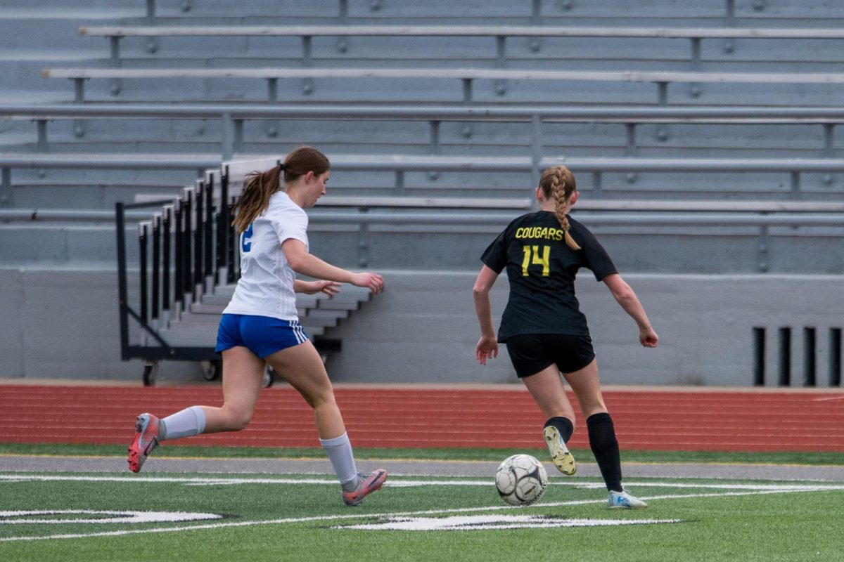 Intercepting the ball, sophomore Gracie Feltes breaks free from the Xavier opponent.  