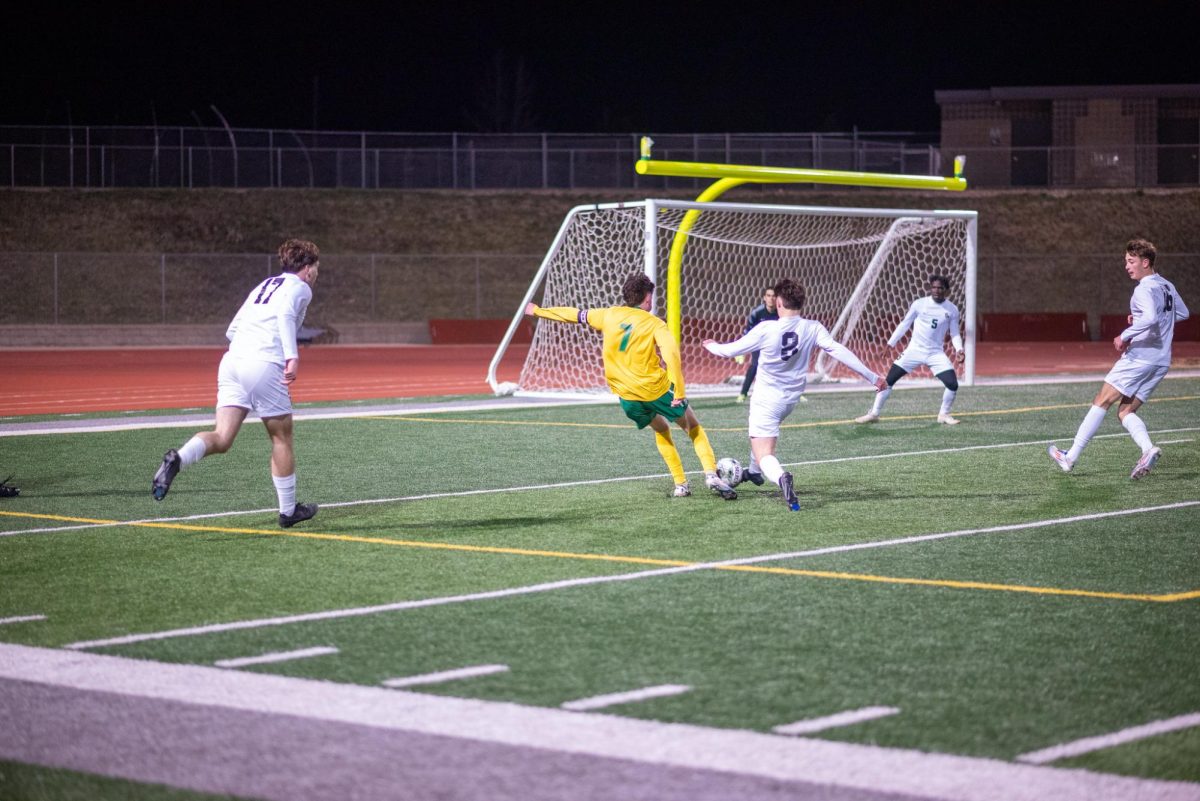 Taking a heavily contested shot, senior Issac Schmidt looks to score a goal.