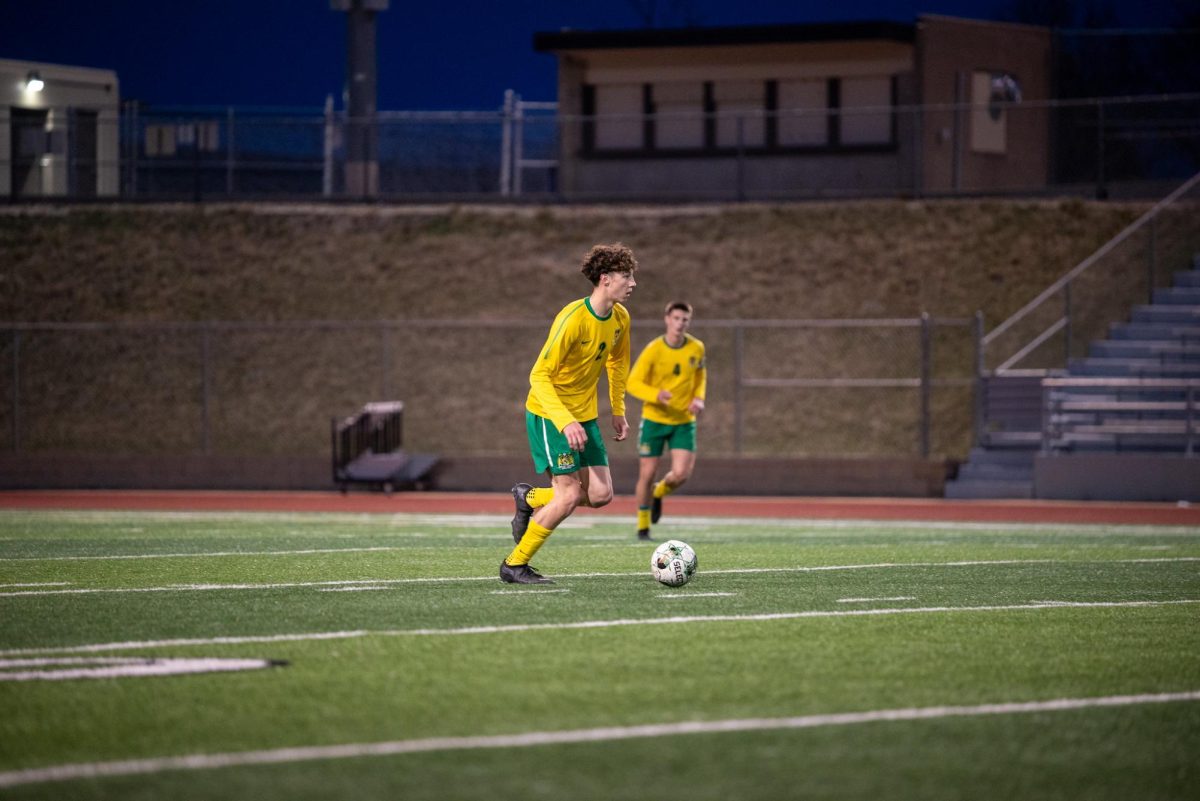Dribbling up the pitch, junior Layne Bowers looks to push the ball upfield.