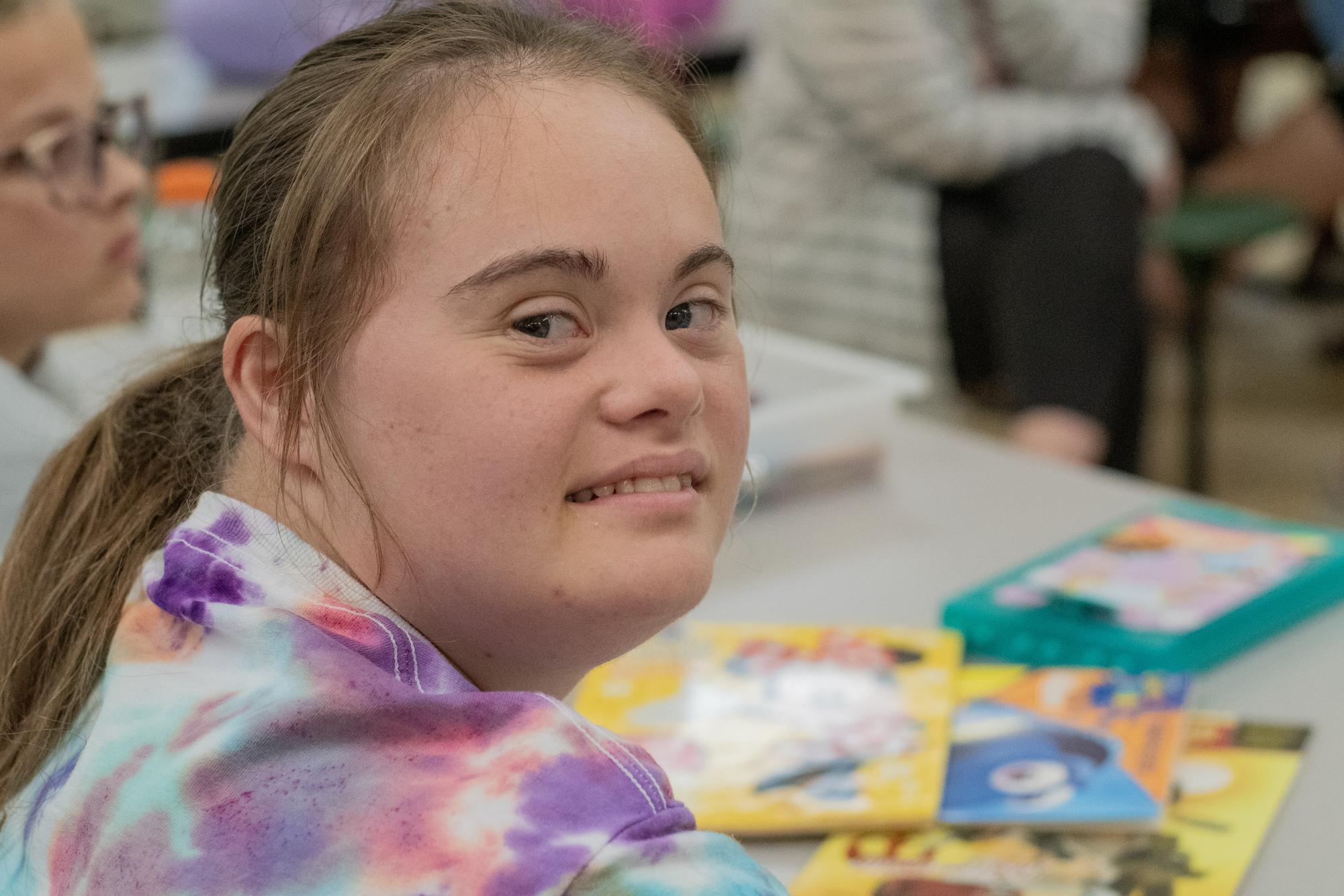 Ashlyn Presley smiles while coloring during the Best Buddie tie dye party. 