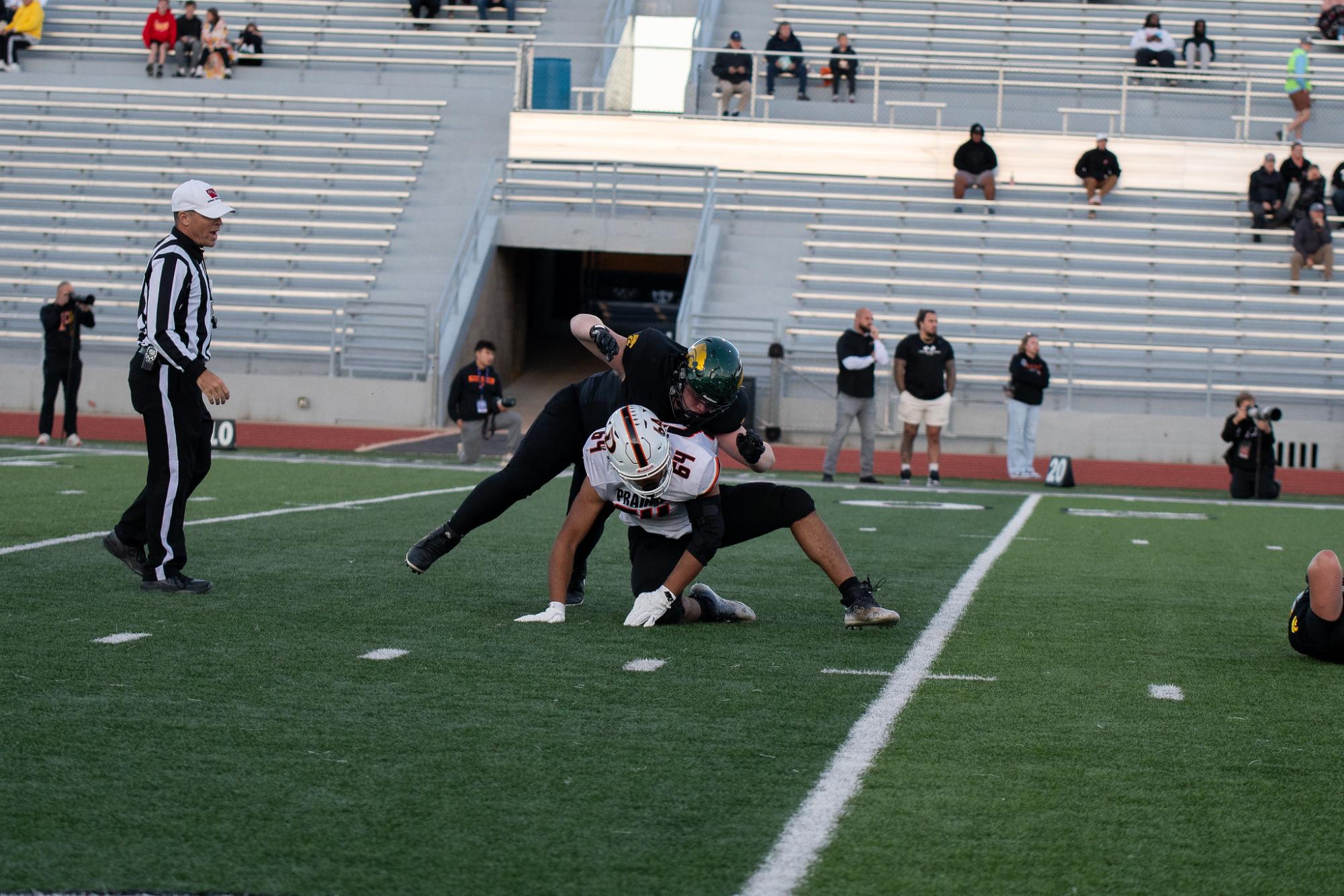 While protecting Senior quarterback Will Woodring, Freshman Lineman Grady Farley pancakes Prairie defender. 