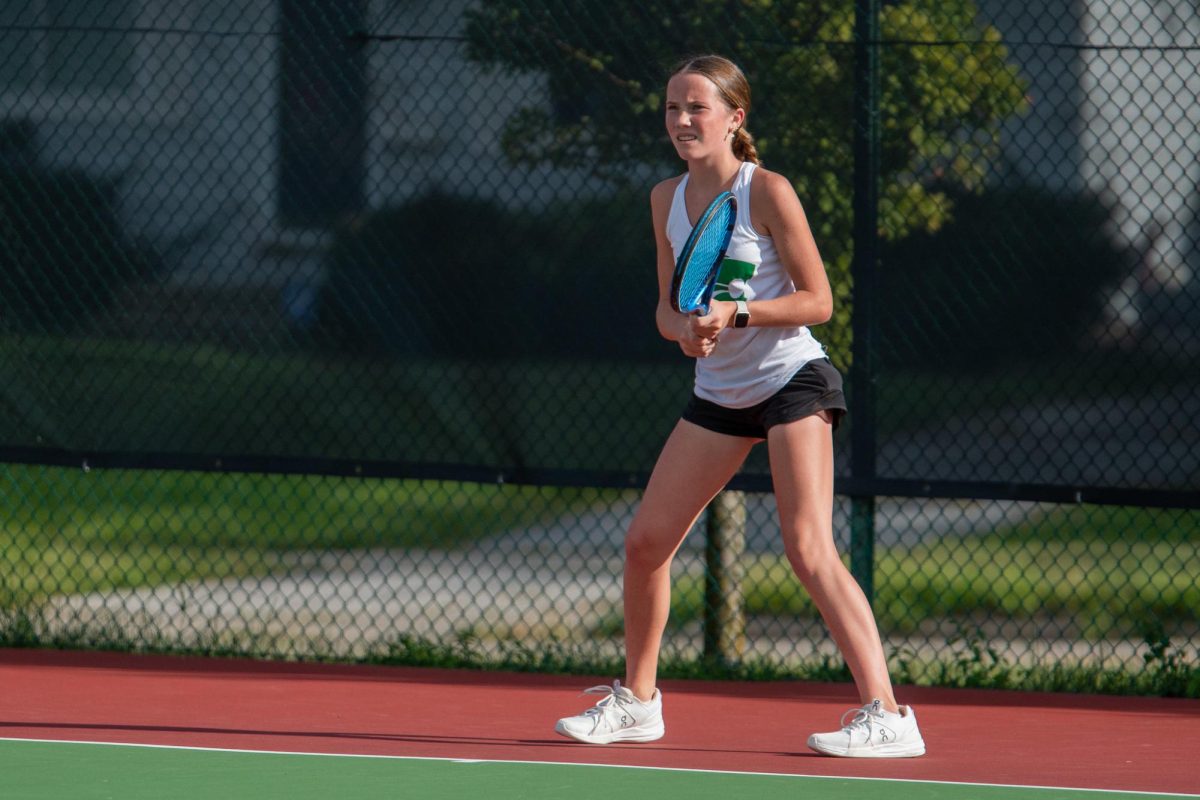 Waiting for the serve, Freshman Aubrey Paulson stands ready to swing the racket