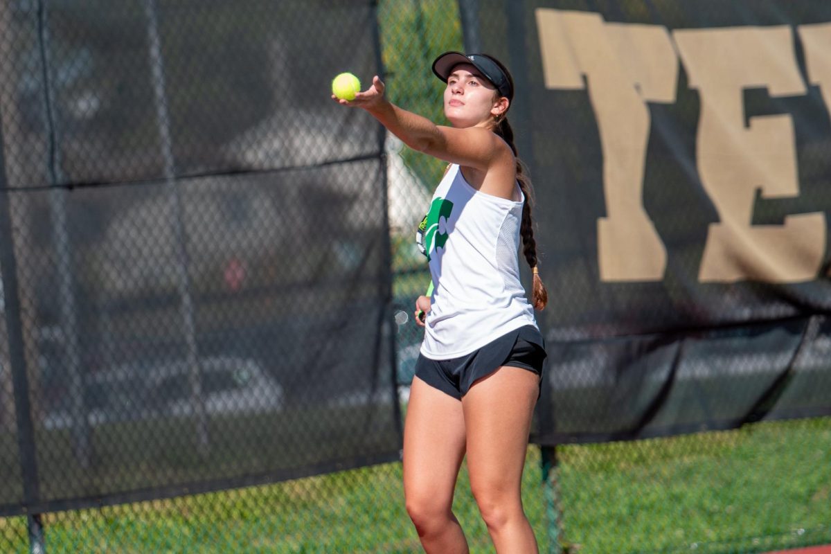 Throwing the ball in the air, Senior Catilyn Ruggeri   prepares the serve.
