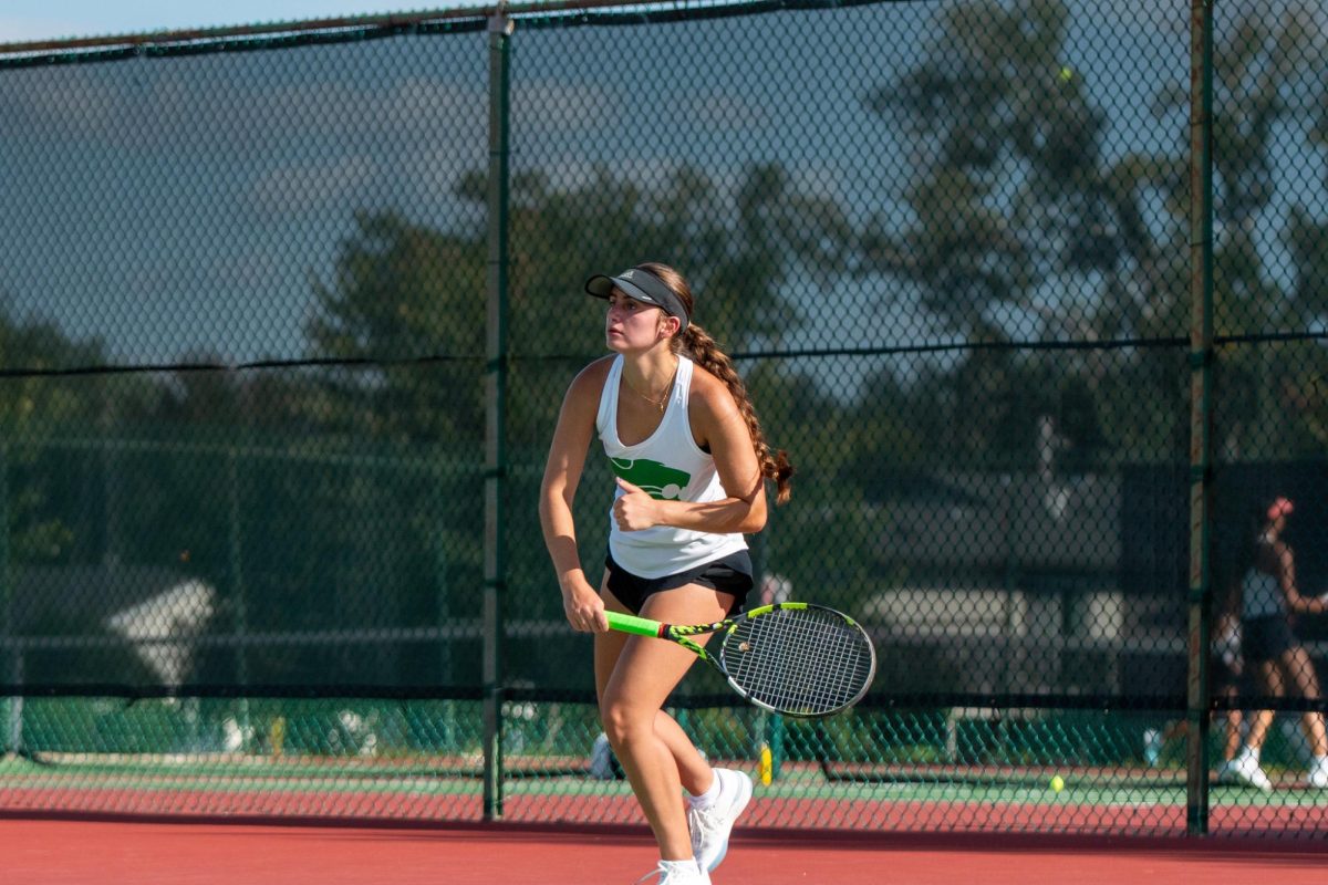 Swinging at the serve, Senior Catilyn Ruggeri hits the ball back over the net.