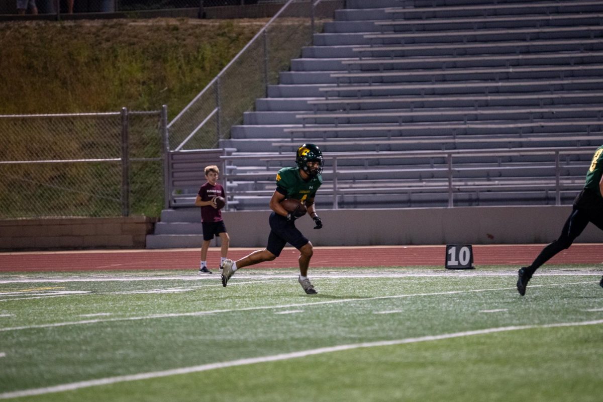 Catching the kickoff, Senior Louis Smith takes off down the field to return the ball. 