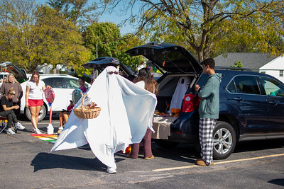 Representing Student Government, a Kennedy High School student runs around Trunk-or-Treat dressed as a ghost. 
